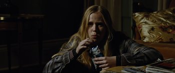 Movie still from “Jack Reacher: Never Go Back” (2016), directed by Edward Zwick – A woman sitting at a table eating a snack; Medium shot, Over the shoulder angle