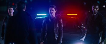 Movie still from “Jack Reacher: Never Go Back” (2016), directed by Edward Zwick – A woman standing in front of police lights at night; Medium shot, Low angle