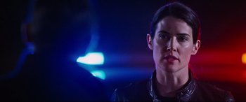 Movie still from “Jack Reacher: Never Go Back” (2016), directed by Edward Zwick – A man in a leather jacket standing in front of a blue light; Close Up shot, Over the shoulder angle