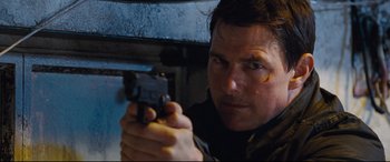Movie still from “Jack Reacher: Never Go Back” (2016), directed by Edward Zwick – A person holding a gun; Close Up shot, Low angle