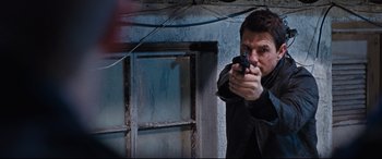 Movie still from “Jack Reacher: Never Go Back” (2016), directed by Edward Zwick – A man holding a gun in his hand; Close Up shot, Over the shoulder angle