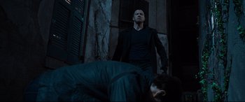 Movie still from “Jack Reacher: Never Go Back” (2016), directed by Edward Zwick – A man standing next to another man on the ground; Medium shot, Low angle
