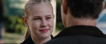 Movie still from “Jack Reacher: Never Go Back” (2016), directed by Edward Zwick – A young woman smiles at the camera as a young man looks on; Close Up shot, Over the shoulder angle