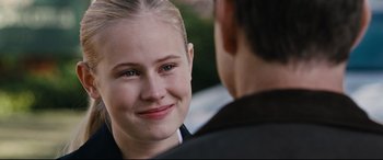 Movie still from “Jack Reacher: Never Go Back” (2016), directed by Edward Zwick – A young woman smiling at a man in a suit; Close Up shot, Over the shoulder angle