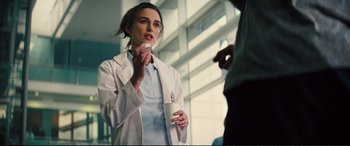 Movie still from “Jack Ryan: Shadow Recruit” (2014), directed by Kenneth Branagh – A woman in a white lab coat holding a cup of coffee; Close Up shot, Over the shoulder angle