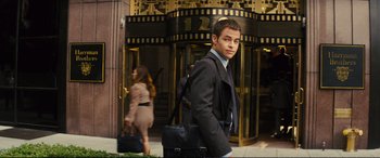 Movie still from “Jack Ryan: Shadow Recruit” (2014), directed by Kenneth Branagh – A man in a suit and tie carrying a briefcase; Medium shot, Over the shoulder angle