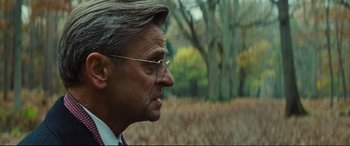 Movie still from “Jack Ryan: Shadow Recruit” (2014), directed by Kenneth Branagh – An older man wearing glasses looking off into the distance; Close Up shot, Over the shoulder angle