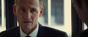 Movie still from “Jack Ryan: Shadow Recruit” (2014), directed by Kenneth Branagh – A person wearing a suit and tie; Close Up shot, Over the shoulder angle