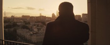 Movie still from “Jack Ryan: Shadow Recruit” (2014), directed by Kenneth Branagh – A man standing in front of a city skyline at sunset; Medium shot, Low angle