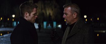 Movie still from “Jack Ryan: Shadow Recruit” (2014), directed by Kenneth Branagh – Two men are standing in the dark talking to each other; Close Up shot, Over the shoulder angle