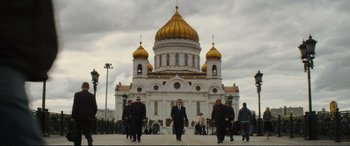 Movie still from “Jack Ryan: Shadow Recruit” (2014), directed by Kenneth Branagh – A group of men walking in front of a building; Wide shot, Low angle