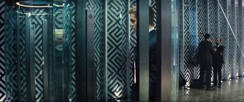 Movie still from “Jack Ryan: Shadow Recruit” (2014), directed by Kenneth Branagh – A man in a suit standing behind a metal fence; Wide shot, Low angle