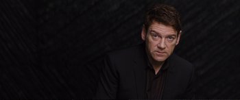 Movie still from “Jack Ryan: Shadow Recruit” (2014), directed by Kenneth Branagh – A person wearing a suit and tie; Close Up shot, Over the shoulder angle