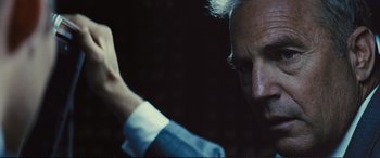 Movie still from “Jack Ryan: Shadow Recruit” (2014), directed by Kenneth Branagh – An older man in a blue shirt and a white shirt; Close Up shot, Over the shoulder angle