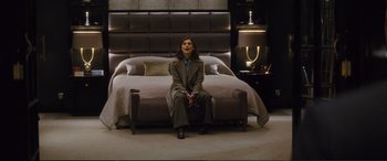 Movie still from “Jack Ryan: Shadow Recruit” (2014), directed by Kenneth Branagh – A woman sitting on the edge of a bed in front of a large bed; Wide shot, Low angle