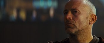 Movie still from “Jack Ryan: Shadow Recruit” (2014), directed by Kenneth Branagh – A man with a bald head is looking into the distance; Close Up shot, Low angle