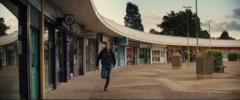Movie still from “Jack Ryan: Shadow Recruit” (2014), directed by Kenneth Branagh – A man running down a street in a city; Wide shot, Low angle