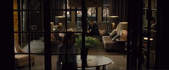Movie still from “Jack Ryan: Shadow Recruit” (2014), directed by Kenneth Branagh – A group of people sitting on couches in a living room; Wide shot, Over the shoulder angle