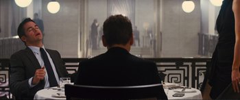 Movie still from “Jack Ryan: Shadow Recruit” (2014), directed by Kenneth Branagh – A man sitting in front of a large window; Medium shot, Over the shoulder angle