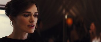 Movie still from “Jack Ryan: Shadow Recruit” (2014), directed by Kenneth Branagh – A woman's face in front of a dark background; Close Up shot, Over the shoulder angle