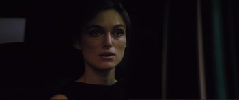Movie still from “Jack Ryan: Shadow Recruit” (2014), directed by Kenneth Branagh – A woman is looking at the camera in the dark; Close Up shot, Over the shoulder angle