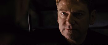 Movie still from “Jack Ryan: Shadow Recruit” (2014), directed by Kenneth Branagh – A man's face with a dark background; Close Up shot, Low angle