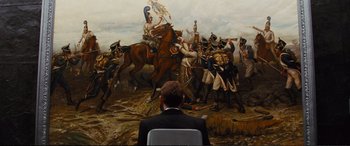 Movie still from “Jack Ryan: Shadow Recruit” (2014), directed by Kenneth Branagh – A man sitting in front of a painting of soldiers on horses; Wide shot, Over the shoulder angle