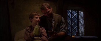 Movie still from “Jack the Giant Slayer” (2013), directed by Bryan Singer – A man and a boy sitting next to each other; Medium shot, Low angle