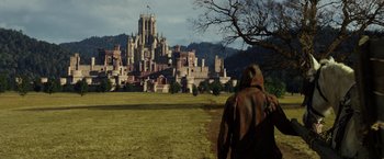 Movie still from “Jack the Giant Slayer” (2013), directed by Bryan Singer – A man in a hooded jacket looking out at a castle; Extreme Wide shot, Low angle