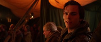 Movie still from “Jack the Giant Slayer” (2013), directed by Bryan Singer – A young man smiles for the camera in front of an audience; Close Up shot, Over the shoulder angle