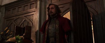 Movie still from “Jack the Giant Slayer” (2013), directed by Bryan Singer – A man dressed in medieval clothing standing in front of a wall; Medium shot, Low angle