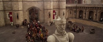 Movie still from “Jack the Giant Slayer” (2013), directed by Bryan Singer – A crowd of people standing in front of a statue of a king; Wide shot, High angle