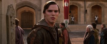 Movie still from “Jack the Giant Slayer” (2013), directed by Bryan Singer – A young man in medieval garb standing in front of a building; Close Up shot, Over the shoulder angle