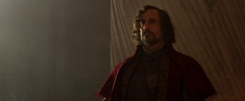 Movie still from “Jack the Giant Slayer” (2013), directed by Bryan Singer – A man with long hair and a beard wearing a red cape; Close Up shot, Low angle