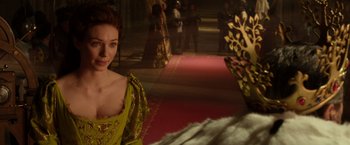 Movie still from “Jack the Giant Slayer” (2013), directed by Bryan Singer – A woman standing in front of other people in a room; Medium shot, Over the shoulder angle