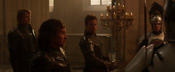 Movie still from “Jack the Giant Slayer” (2013), directed by Bryan Singer – Two men dressed up in armor in a room with candles; Medium shot, Over the shoulder angle