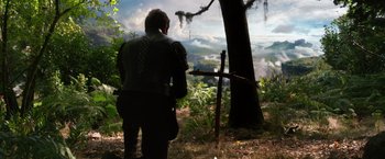 Movie still from “Jack the Giant Slayer” (2013), directed by Bryan Singer – A man standing next to a tree in the woods; Wide shot, Low angle