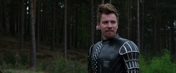 Movie still from “Jack the Giant Slayer” (2013), directed by Bryan Singer – A man in a leather suit standing next to a forest; Close Up shot, Over the shoulder angle
