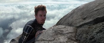 Movie still from “Jack the Giant Slayer” (2013), directed by Bryan Singer – A man in a black suit climbing a rock; Medium shot, Low angle