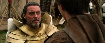 Movie still from “Jack the Giant Slayer” (2013), directed by Bryan Singer – A man wearing a gold armor and a beard; Close Up shot, Over the shoulder angle