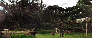Movie still from “Jack the Giant Slayer” (2013), directed by Bryan Singer – A man standing in a field next to a tree; Extreme Wide shot, Low angle