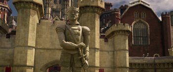 Movie still from “Jack the Giant Slayer” (2013), directed by Bryan Singer – A statue of a man in medieval garb stands in front of a castle; Wide shot, Low angle