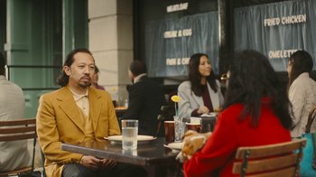 Movie still from “Jackass Forever” (2022), directed by Jeff Tremaine – A group of people sitting around a table; Medium shot, Over the shoulder angle