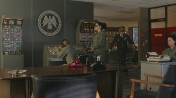 Movie still from “Jackass Forever” (2022), directed by Jeff Tremaine – A group of people standing in a room; Wide shot, Over the shoulder angle