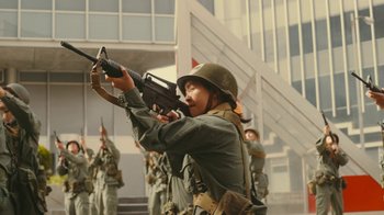 Movie still from “Jackass Forever” (2022), directed by Jeff Tremaine – A group of men in uniform are holding guns; Medium shot, Low angle