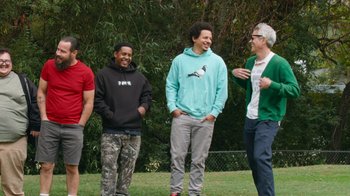 Movie still from “Jackass Forever” (2022), directed by Jeff Tremaine – A group of young men standing next to each other on a field; Medium shot, Low angle