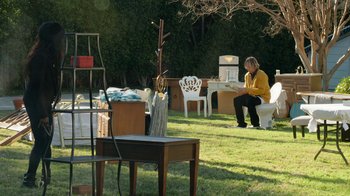 Movie still from “Jackass Forever” (2022), directed by Jeff Tremaine – A man sitting on a chair in the grass; Wide shot, High angle
