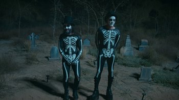 Movie still from “Jackass Forever” (2022), directed by Jeff Tremaine – A couple of people that are dressed like skeletons; Wide shot, High angle