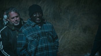 Movie still from “Jackass Forever” (2022), directed by Jeff Tremaine – A man wearing a plaid shirt and a hat; Medium shot, High angle