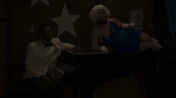 Movie still from “Jackass Forever” (2022), directed by Jeff Tremaine – A man in a white suit and a man in a blue dress; Wide shot, High angle